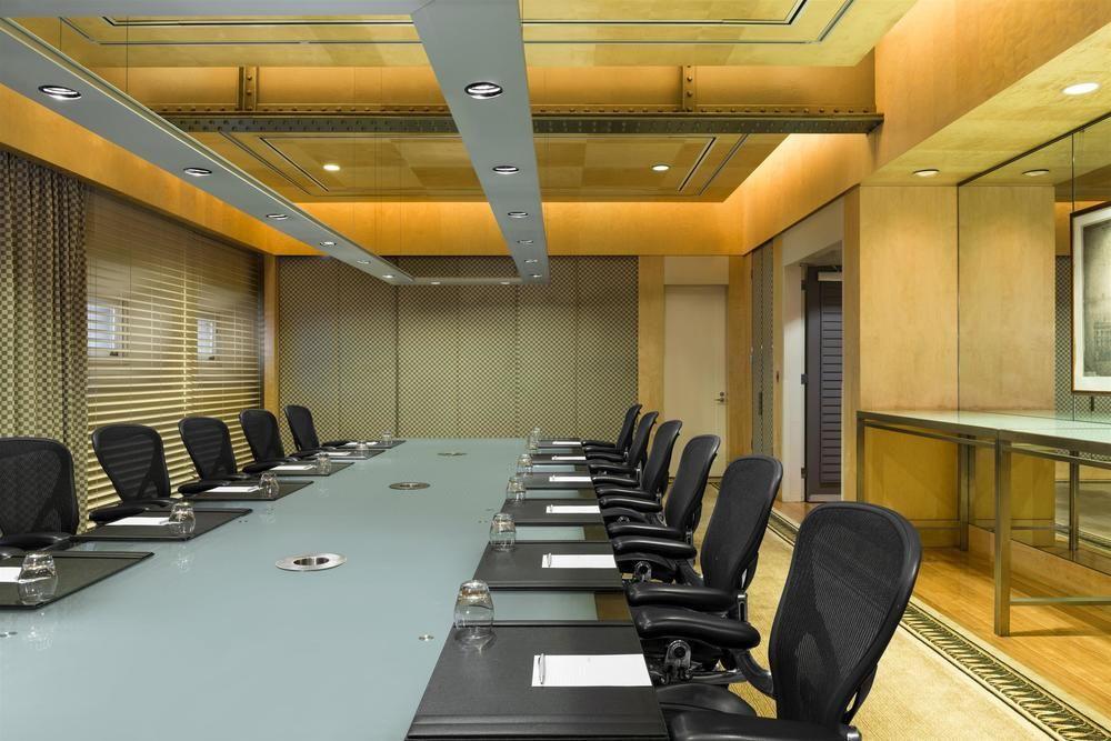 The Fullerton Hotel Sydney Exterior foto The photo shows a modern conference room with a long, rectangular table at the center. There are several ergonomic office chairs lined up on either side of the table. The tabletop appears to be a light-colored glass or a similar material, and it has 