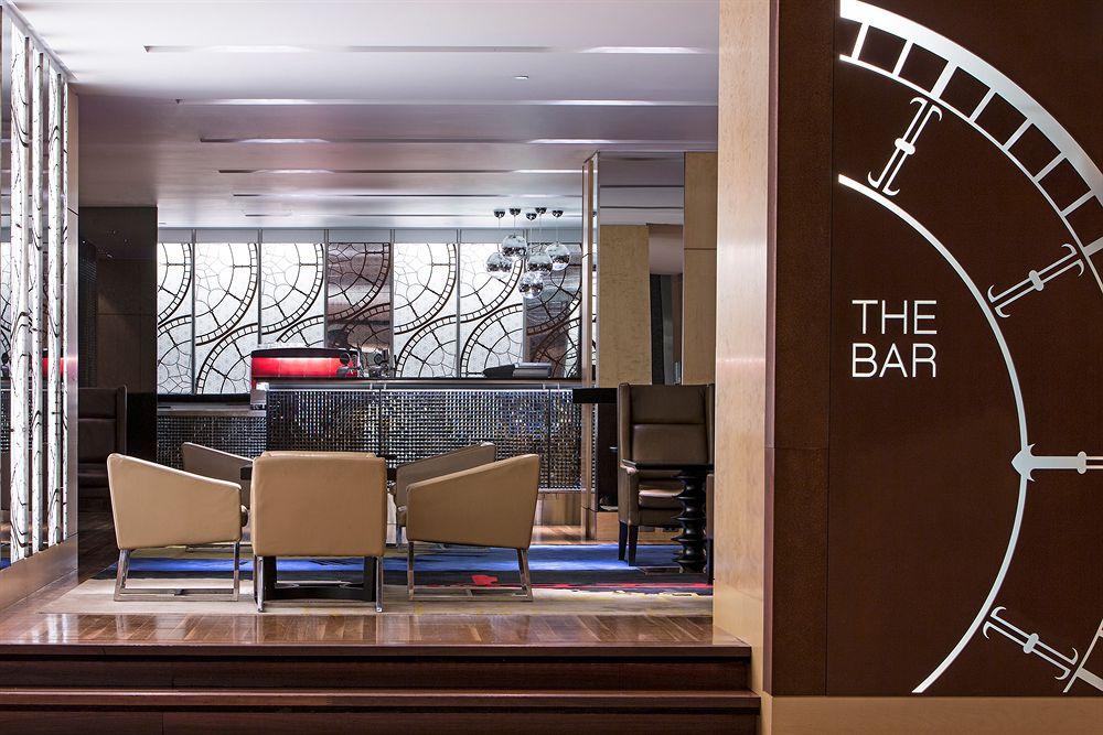 The Fullerton Hotel Sydney Exterior foto The photo shows a modern bar area. On the left side, there's a stylish sign that reads "THE BAR," integrated into a decorative design. In the center, behind a sleek counter, there appears to be a mirror with intricate patterns. The bar itself has a r